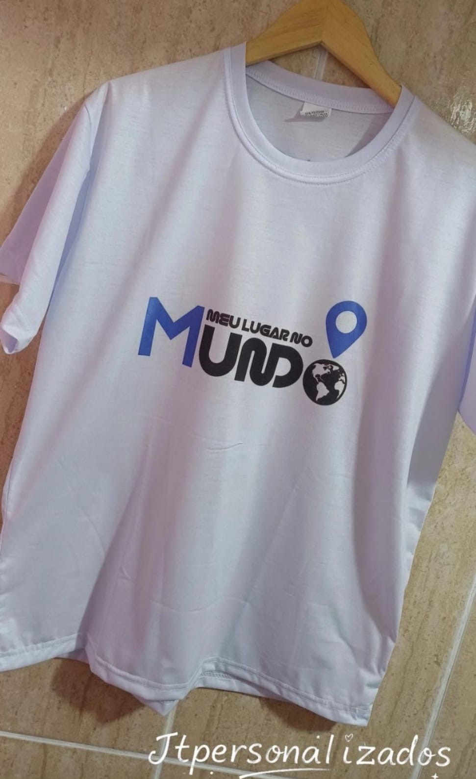 Camiseta branca com a logo Meu Lugar no Mundo em azul e preto, com um globo e um marcador de mapa